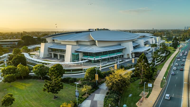 Aerial view of GCCEC’s curved roofs at sunset beside the Gold Coast Highway
