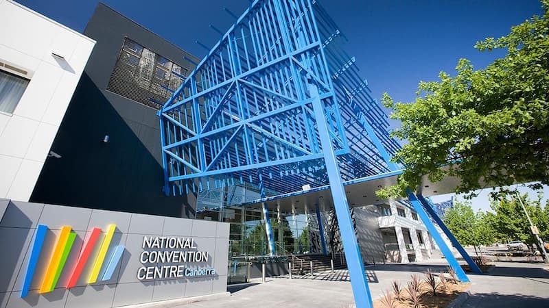 NCCC’s main entrance under its blue steel canopy, beside the rainbow-striped centre sign