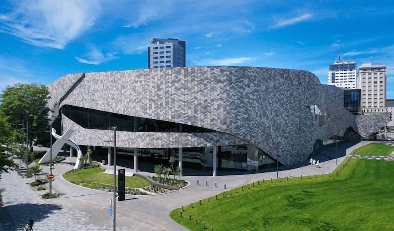 Te Pae’s curved, shimmering facade above a lawn in central Christchurch